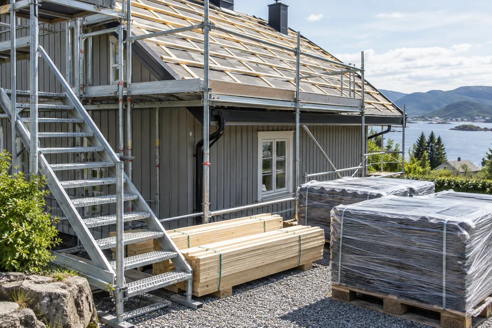 Arbeidsplass med stillas rundt et takbytte – generert illustrasjon.